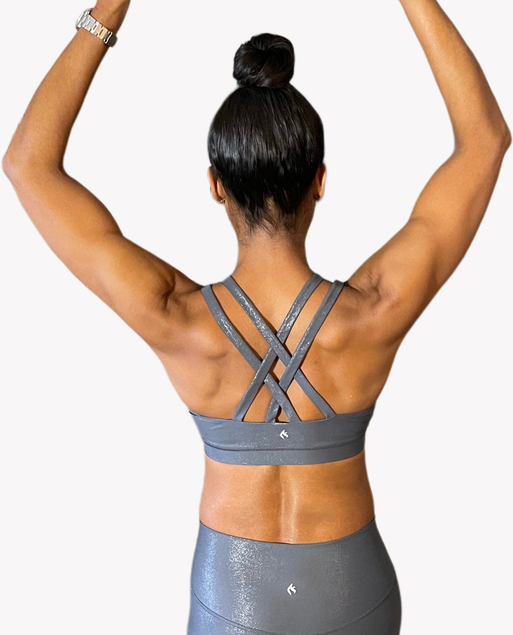 A model with her hands on her hips wears the Glitz & Glam bra with matching leggings.