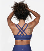 A model showing off the Criss Cross Strappy Back design of the sports bra. 