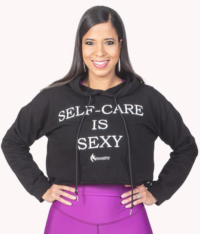 Image of a woman wearing the Self-Care Is Sexy Crop Hoodie from NoorFit.