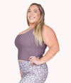 A plus-size woman wearing the Mulberry Crop Top Tank from NoorFit.