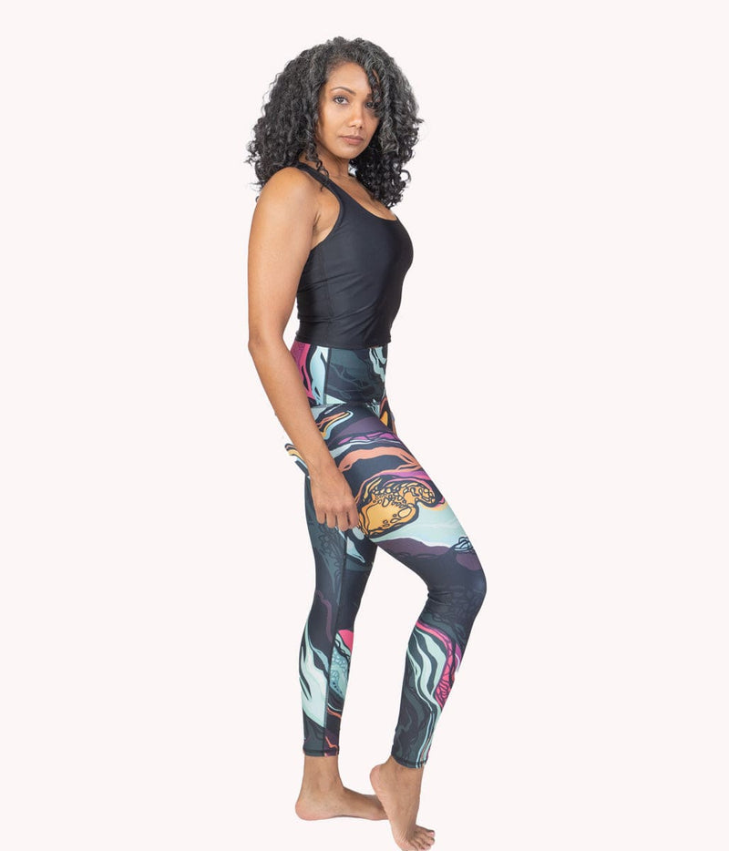 A model standing to the side wearing a pair of Luxe Marble Leggings. 