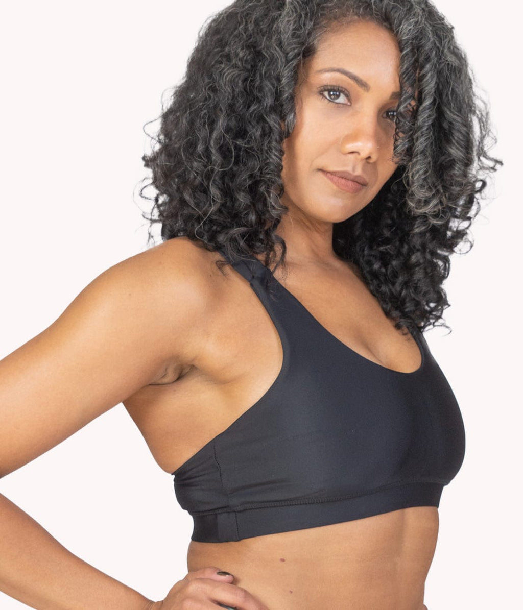 A model wearing the obsidian sports bra with strappy design. 